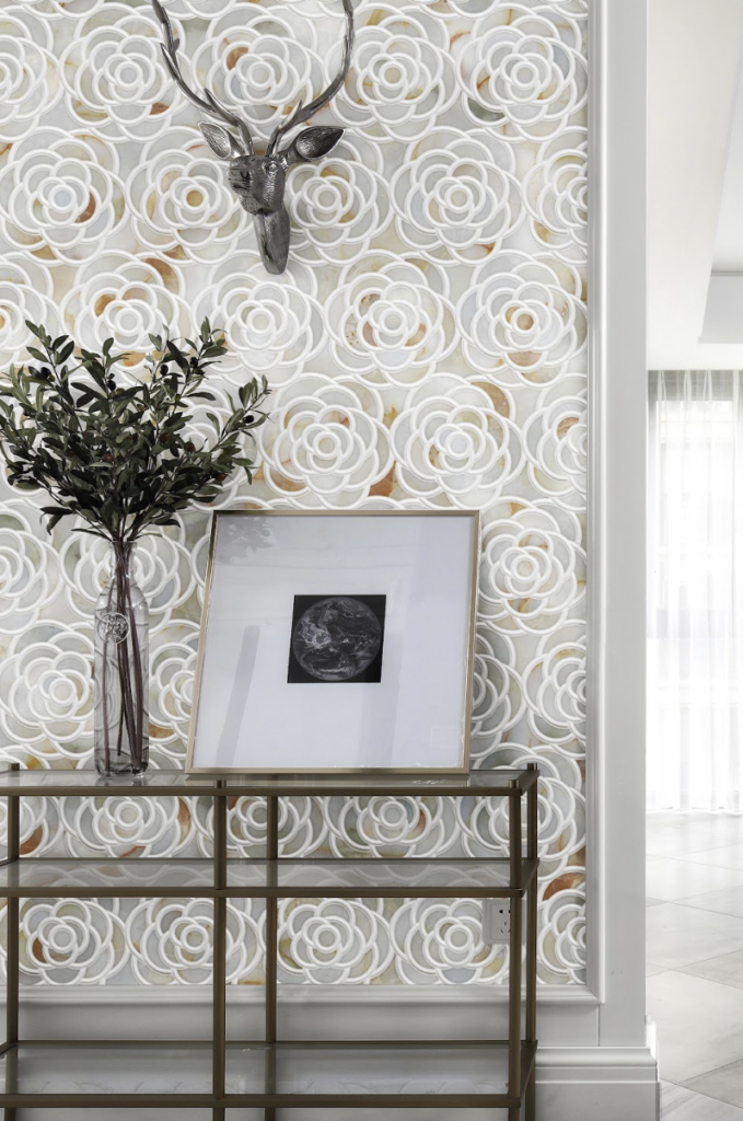 Onyx Rose waterjet mosaic in White Onyx and Thassos marble installed as a feature wall with sculptural rose motifs in a contemporary interior.
