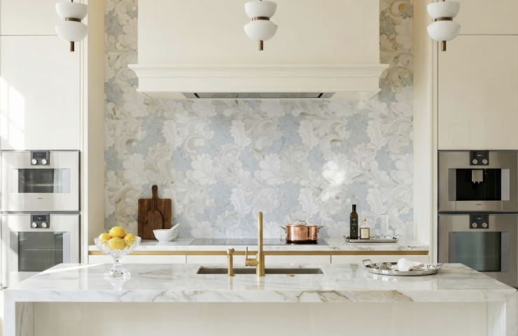 Wildflower waterjet mosaic in Azul Cielo, Thassos, and Calacatta Gold marble used as a floral backsplash behind a range hood in a modern luxury kitchen.